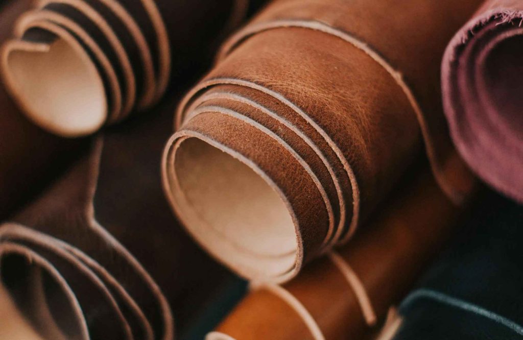 Leather Furniture: Enduring Luxury for Elevated Living 1 mickler-&-co-design-studio-eastern-nc-luxury-leather-furniture-rolls-of-different-colored-leather-in-workroom-high-quality-online-interior-design